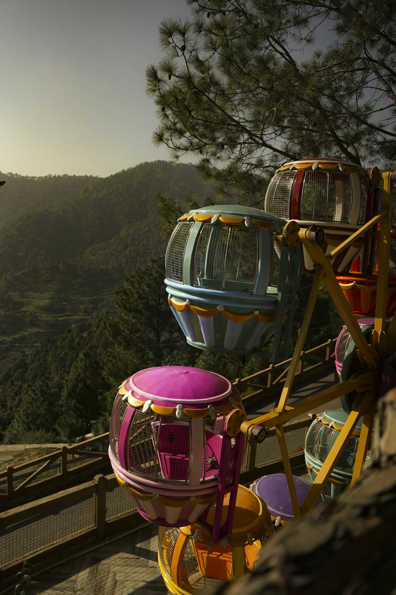 Colourful hot-air-balloon gondolas on a small ride above the valley