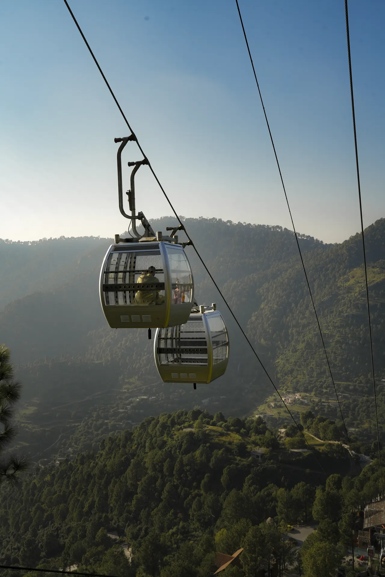 Gondolas hanging from the cable against a blue sky